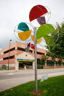 Tall sculpture that looks like a wind vane with colorful shapes.